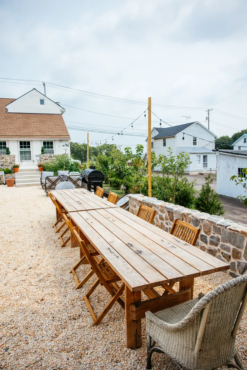 A table laid for lunch outdoors, in the shade.
