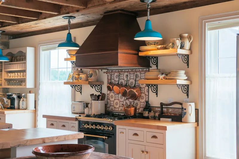 The kitchen — open shelving, a farmhouse sink and a long working counter.