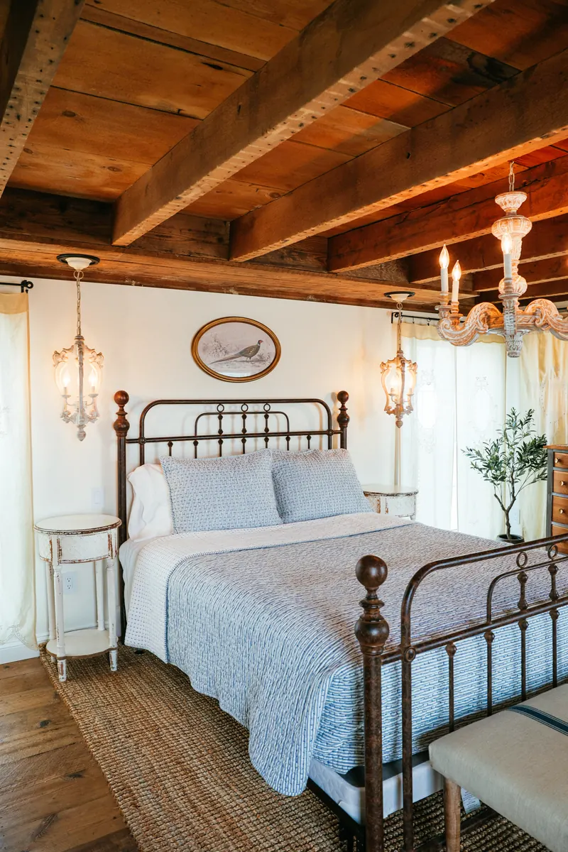 Provence — a stone-walled bedroom under exposed timber beams.