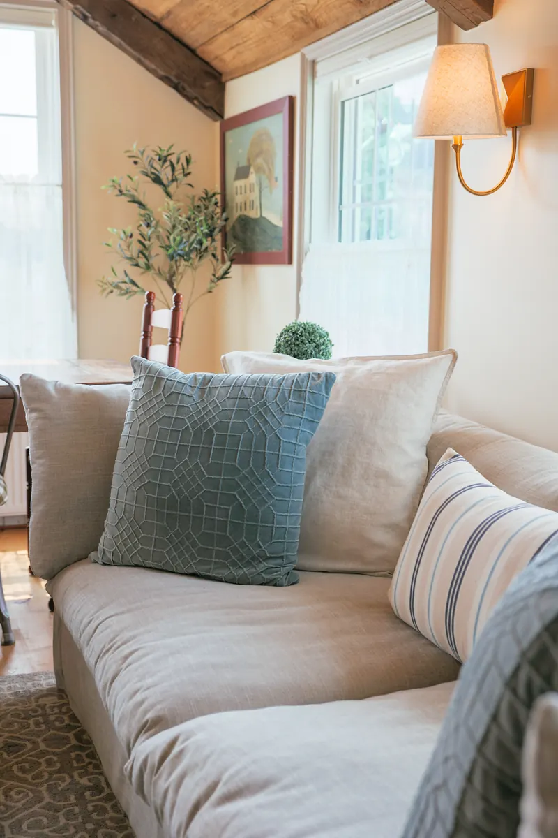 A corner of the living room — a linen sofa against a plastered wall.