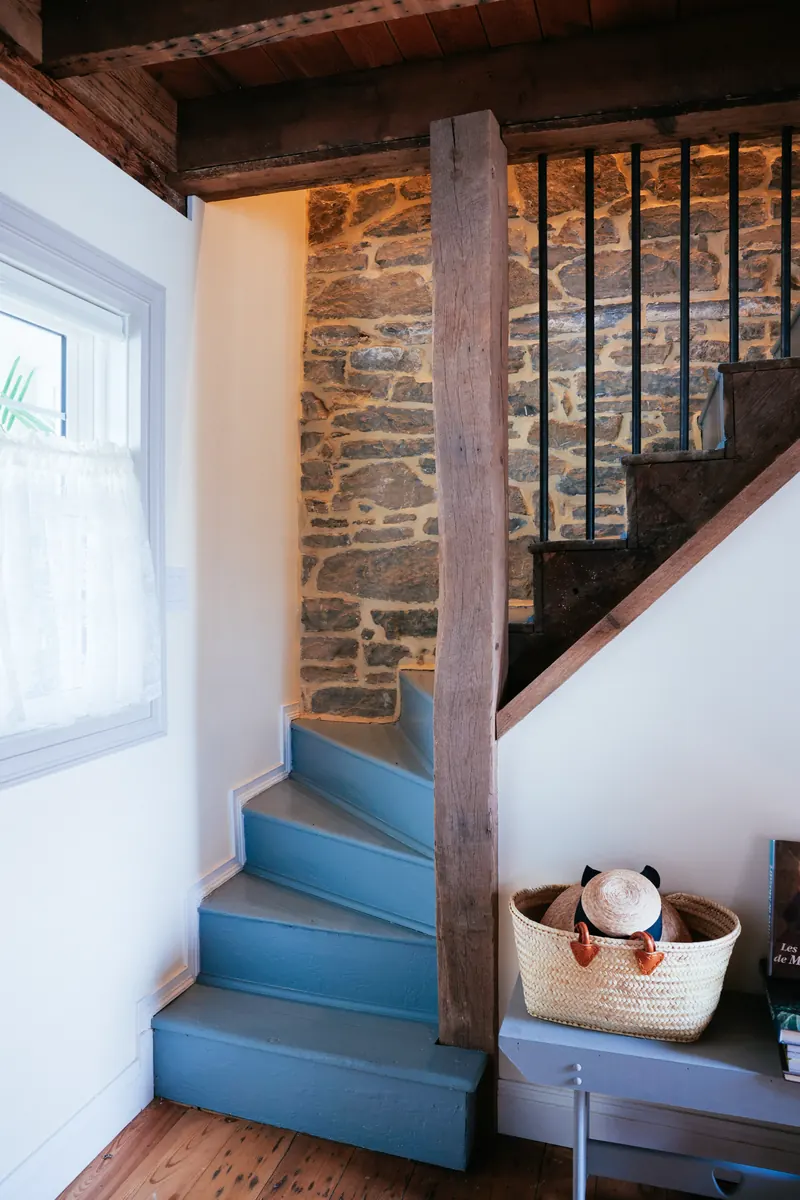 The staircase, turning against a whitewashed wall.